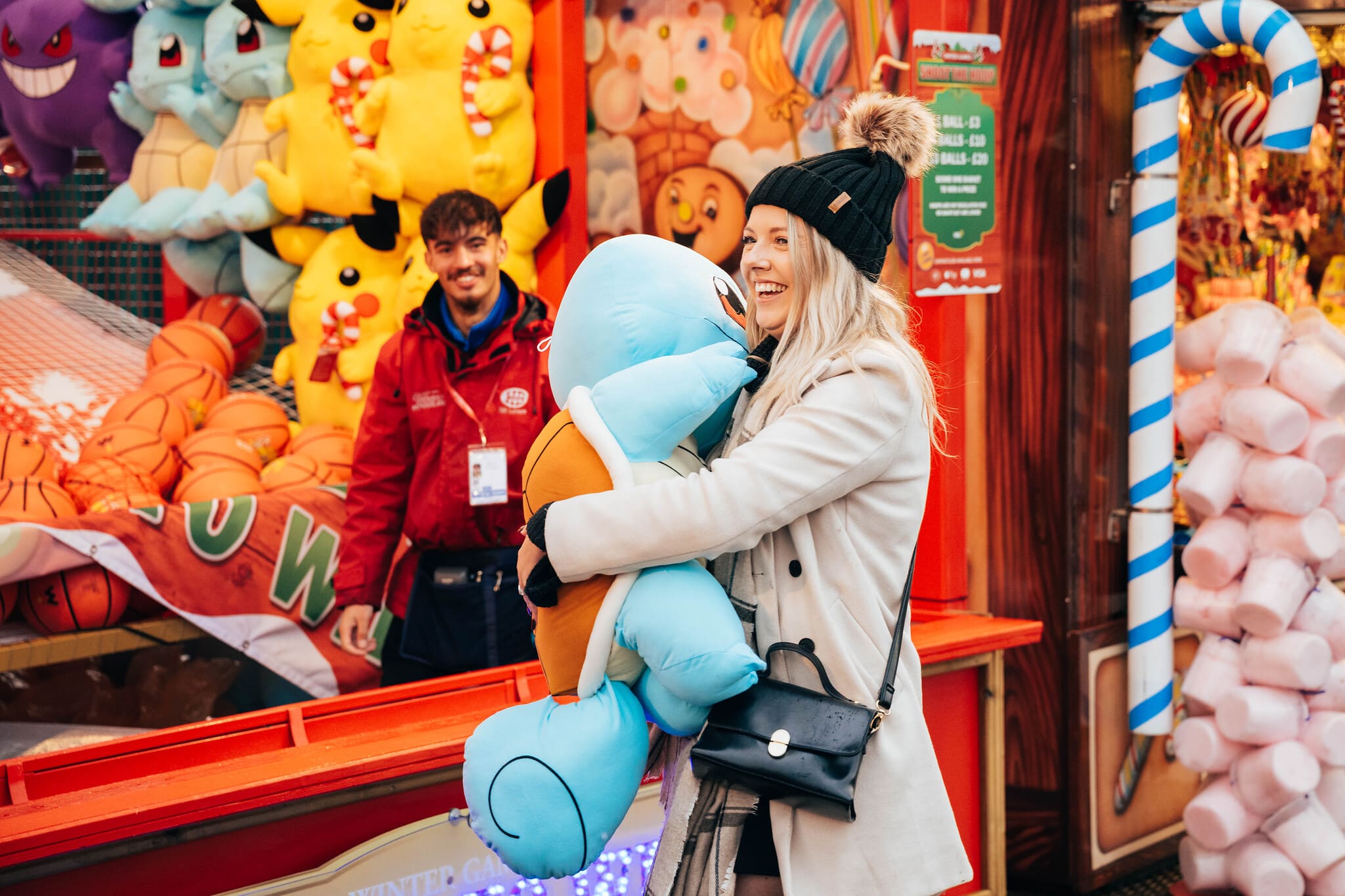 Woman playing bottle game at Winter Wonderland whilst holding a stuffed toy
