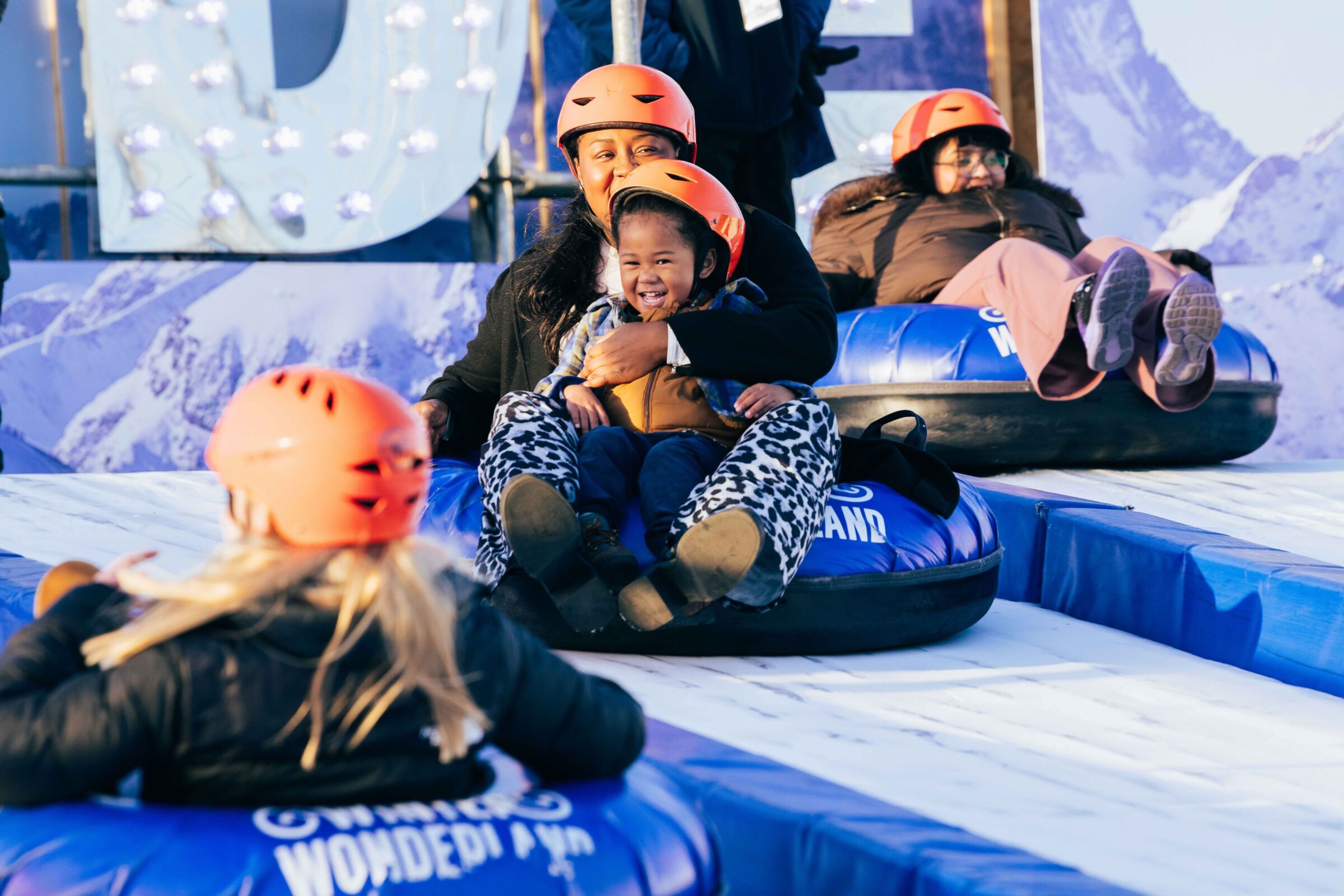 Woman and child sliding down the Real Ice Slide at Winter Wonderland